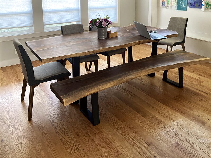 Walnut dining table with a matching live-edge bench on a patterned rug