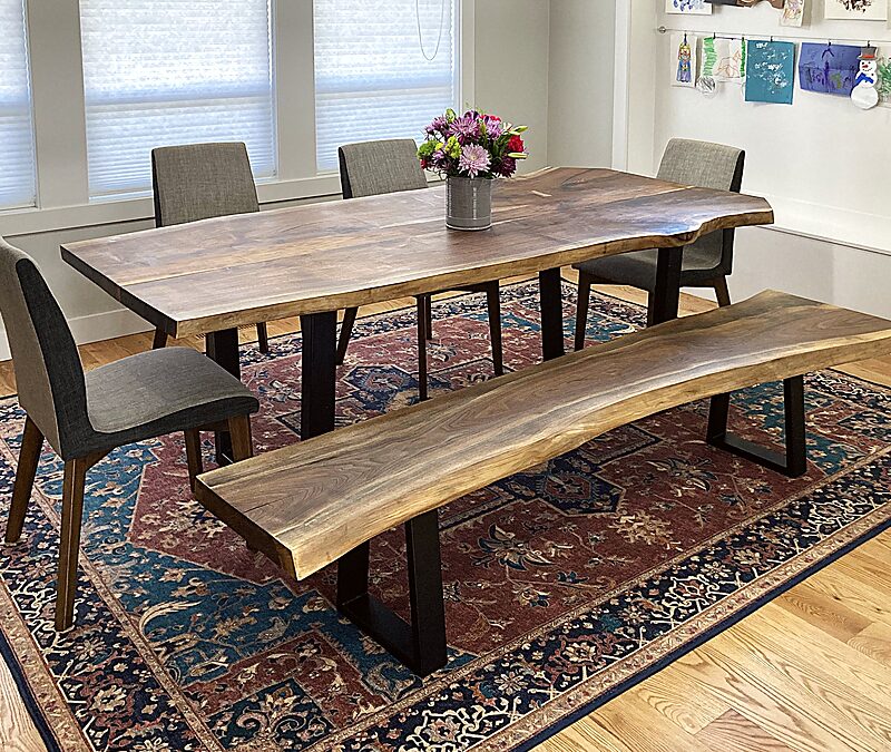 Dining table and bench in a room with a navy accent wall