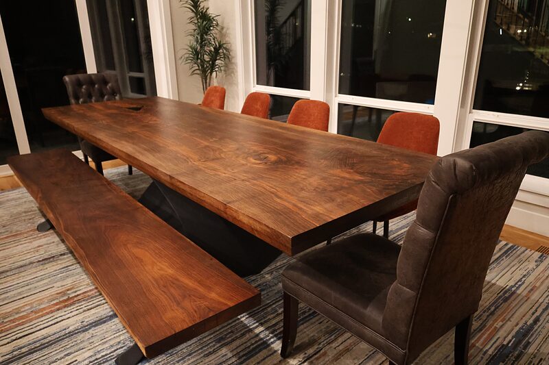Walnut top and bench with upholstered chairs around the Gathering Place table