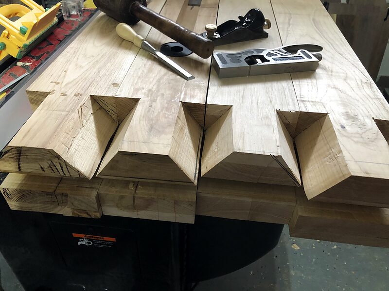 Hand plane resting on a board with freshly cut finger joints