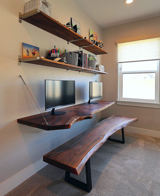 Floating live-edge desk and shelves hung on a wall with slim cable supports