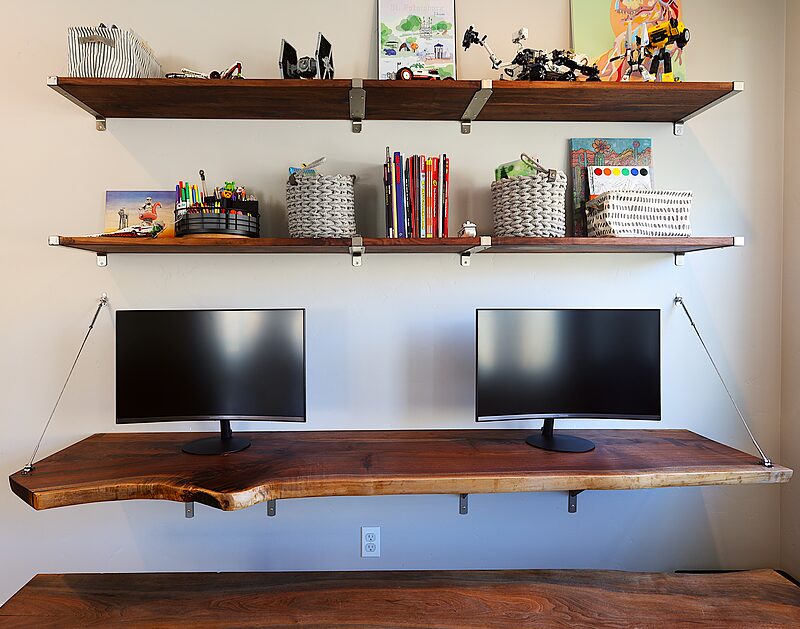 Floating live-edge walnut desk with two monitors and matching floating shelves above