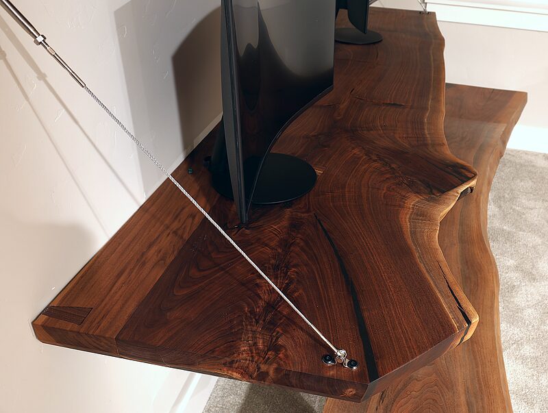 Close-up of the steel cable anchored to the live edge of the Study Hall desk