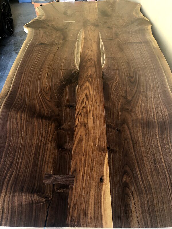 Pair of rough walnut slabs laid side by side before flattening